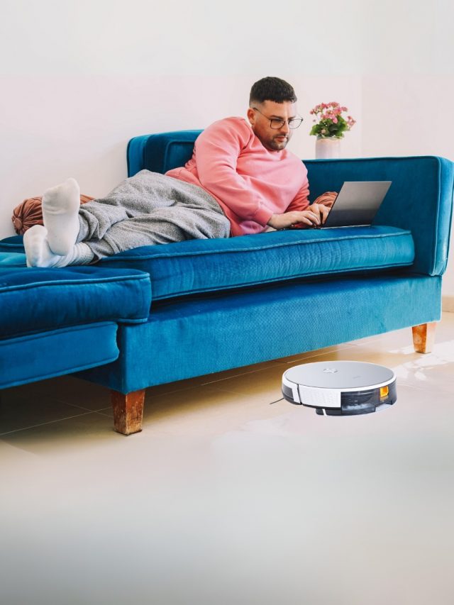 father working and robot vacuum cleaner cleaning the floor