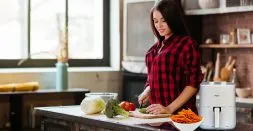 Woman making vegetable fried food in air fryer